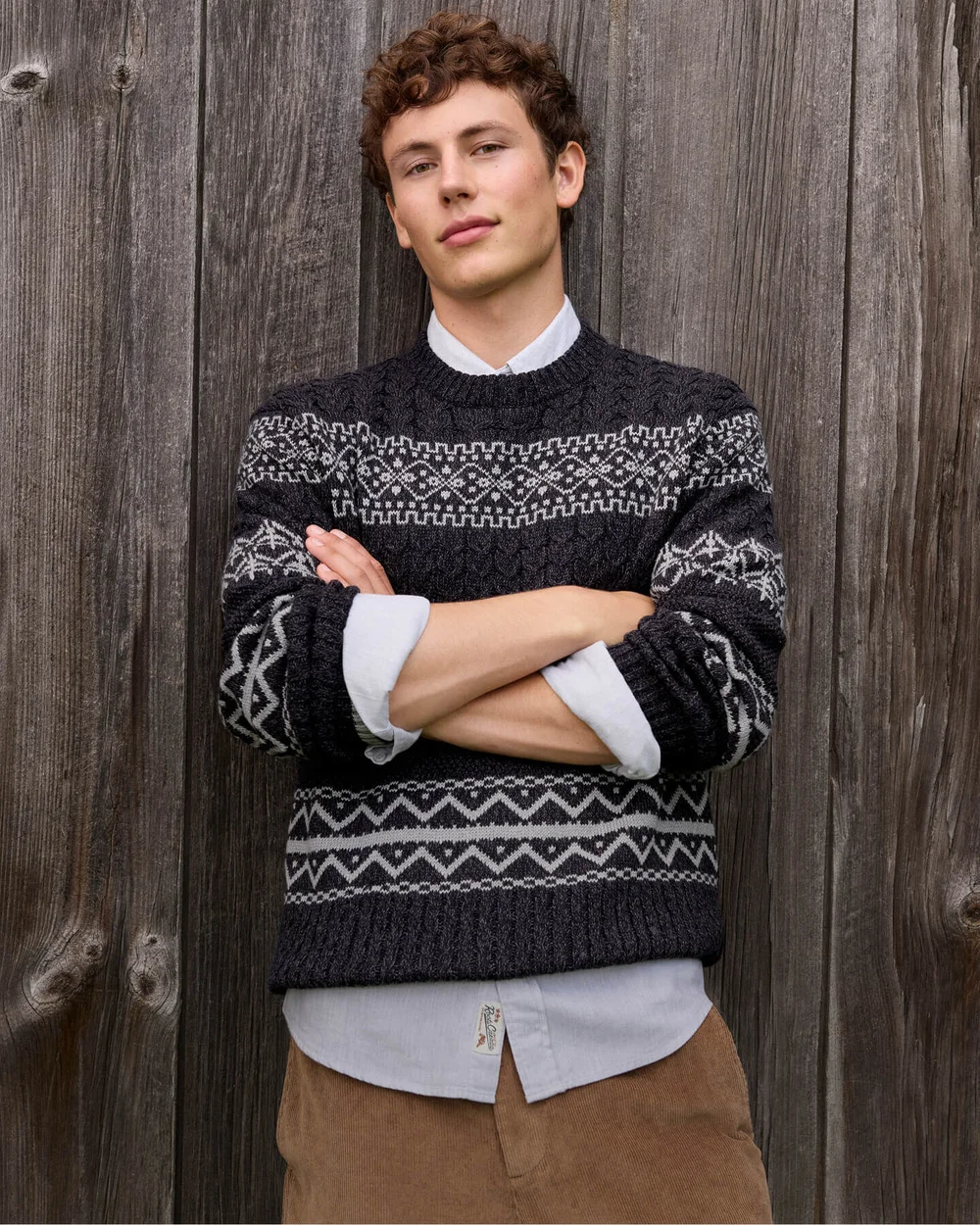 A patterned knit sweater layered over a shirt