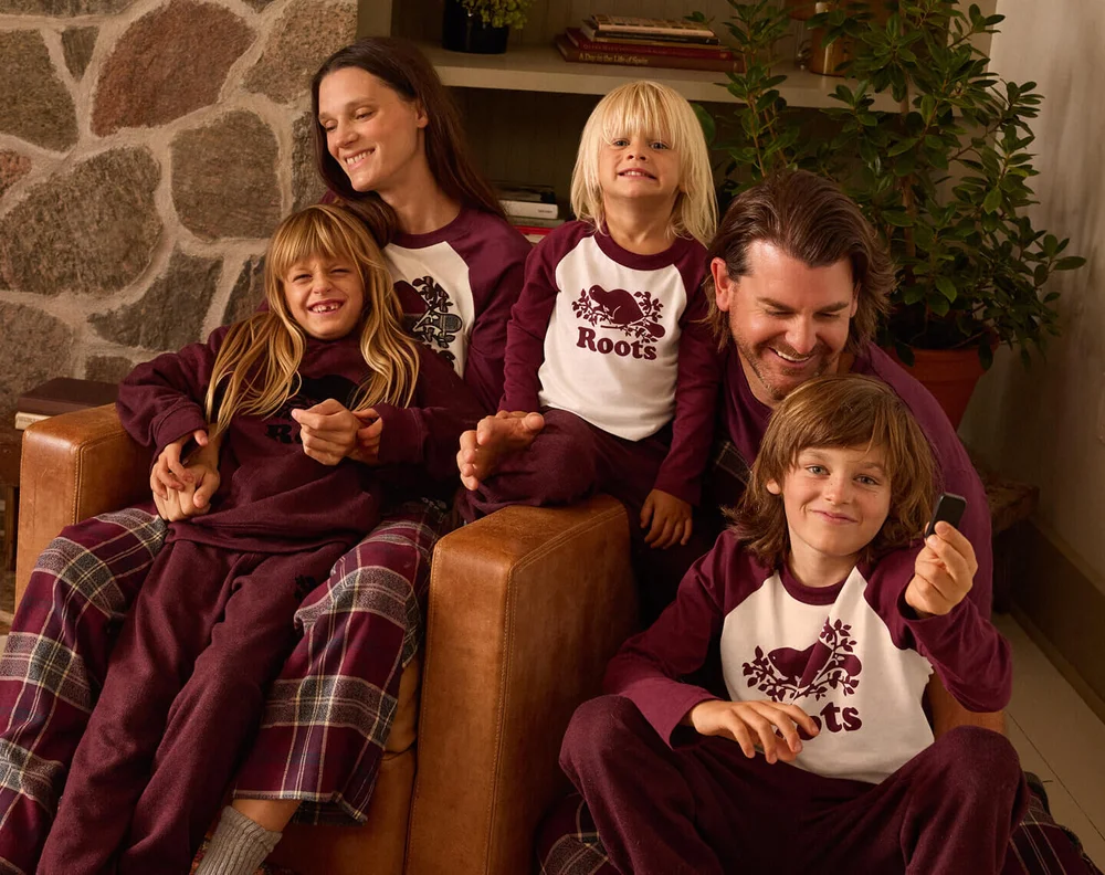 A family unwinding together in matching burgundy layers and plaid pajamas